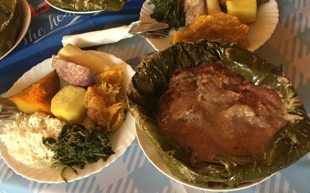 Traditional Ugandan food - the matoke is orange and on the white plate